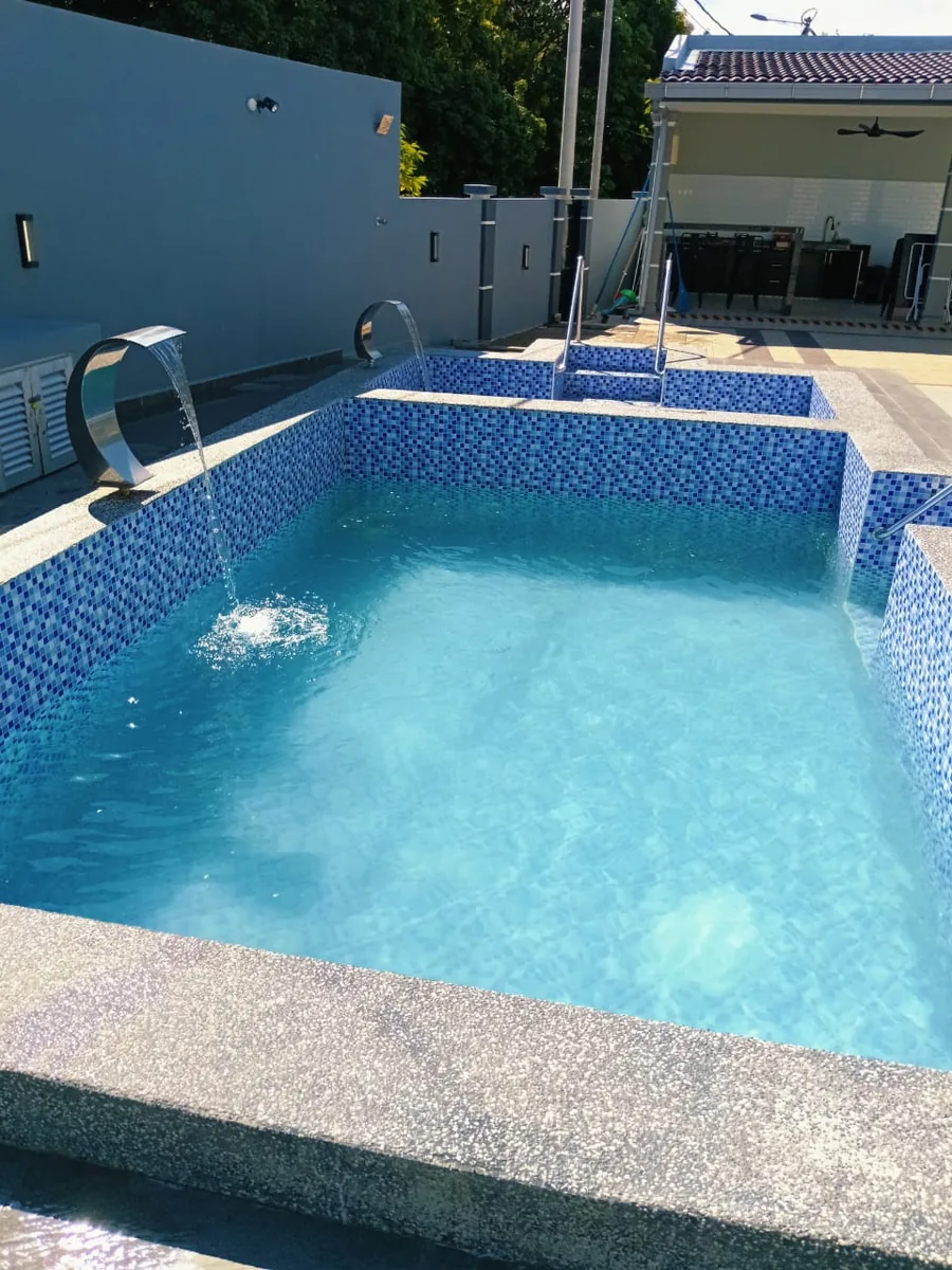 Mosaic tiled pool with clear blue water after cleaning