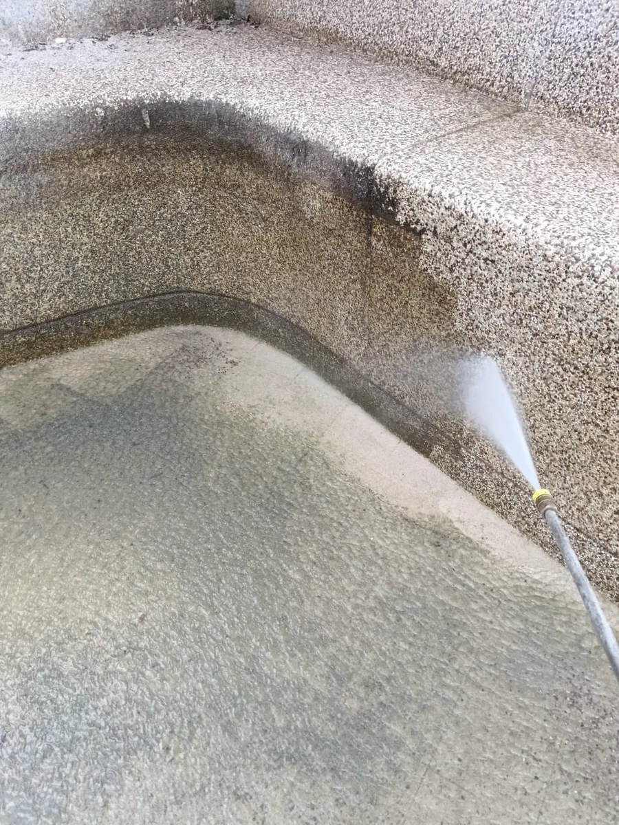 Close-up pressure washing of pool surface buildup